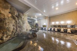 a swimming pool in a room with a rock wall at 銚子グランドホテル in Choshi