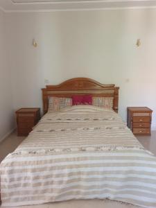 a bedroom with a large bed with two night stands at Appartement in Oujda