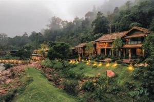 a house in the mountains with lights in the yard at อุ่นไอมาง สะปัน in Ban Huai Ti