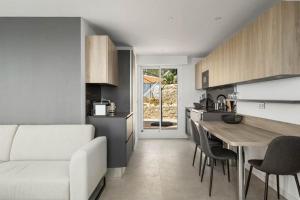 een keuken en een woonkamer met een witte bank en een tafel bij Les Terrasses de Monaco in Roquebrune-Cap-Martin