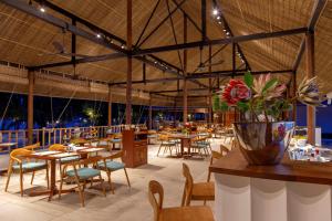 um restaurante com mesas e cadeiras e um vaso de flores em ISLAND CENTER POINT em Koh Rong Sanloem