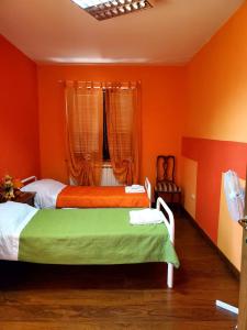 The Spot : سريرين في غرفة بجدران برتقالية