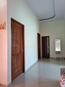 an empty room with a wooden door and white walls at Omah Medina in Klaten