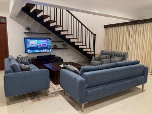 sala de estar con 2 sofás y TV en Lihanda Villa B1, en Kilifi