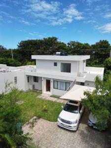 una casa blanca con un coche aparcado delante de ella en Lihanda Villa B1 en Kilifi