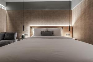 1 dormitorio con 1 cama blanca grande y 1 sofá en Magnes Hotel en Volos
