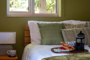 a tray of food on a bed with a plate of food at The Lookout in Fritham