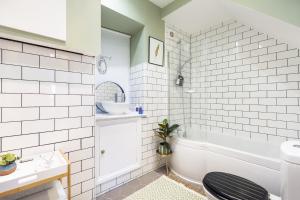 a bathroom with a tub and a sink and a toilet at Hidden Gem – Luxe Clifton Apartment with Views in Bristol