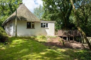 a small white house with a thatch roof at The Lookout in Fritham