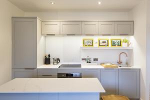 a white kitchen with white cabinets and a sink at Hidden Gem – Luxe Clifton Apartment with Views in Bristol