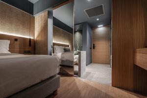 Habitación de hotel con cama y espejo en Magnes Hotel en Volos