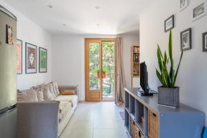 ein Wohnzimmer mit Sofa und Fernseher in der Unterkunft Appart Casa Zio Vaison la Romaine in Vaison-la-Romaine