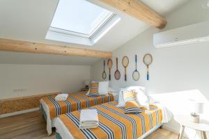 two beds in a bedroom with a skylight at Appart Casa Zio Vaison la Romaine in Vaison-la-Romaine