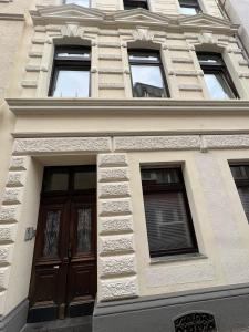 un bâtiment avec une porte marron et plusieurs fenêtres dans l'établissement Retro Appartement im Herzen von Köln Deutz, à Cologne