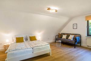 1 dormitorio con 1 cama grande y 1 sofá en Ferienwohnung Zur frischen Quelle en Eußerthal