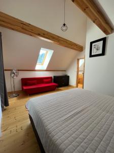1 dormitorio con 1 cama y 1 sofá rojo en Chata Sára, en Snina