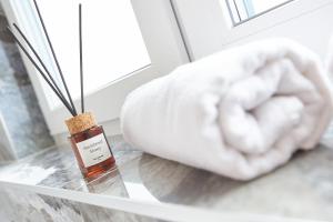 Eine Flasche ätherisches Öl auf einem Glastisch neben einem Bett in der Unterkunft Hotel Crystal in Hajdúszoboszló + 54 Fotos