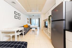 een keuken en een woonkamer met een koelkast bij Spacious Studio with Lake Views - JLT in Dubai