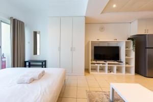 een slaapkamer met een bed en een tv in een kamer bij Spacious Studio with Lake Views - JLT in Dubai