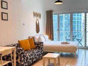 een woonkamer met een bed en een bank bij Spacious Studio with Lake Views - JLT in Dubai