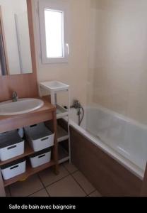een badkamer met een wastafel en een bad bij Apt. 6/8 couchages 200m océan in Moliets-et-Maa