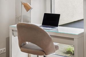 a desk with a laptop computer on top of it at Arbio I 1A Rooms & Apartments Prenzlauerberg Berlin in Berlin