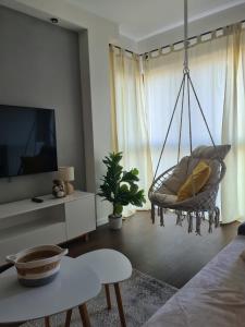 een hangende stoel in een woonkamer met een televisie bij VENICE VILLA Apartment, self check-in 24h, free parking in Poznań