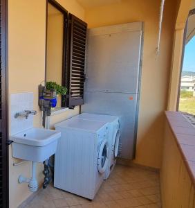 a bathroom with a washing machine and a sink at Tuscan Gallery House in Grosseto