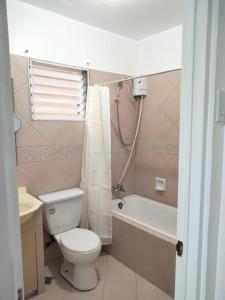 een badkamer met een toilet, een bad en een wastafel bij Vacation Town House Near Mactan Cebu Airport in Mactan