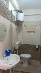 uma casa de banho com um WC branco e um lavatório. em Banabas Homestay em Darjeeling