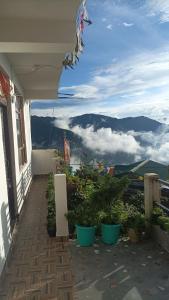 uma varanda de uma casa com vista para as montanhas em Banabas Homestay em Darjeeling