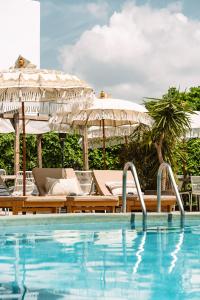 een zwembad met stoelen en parasols naast een resort bij Parco Ibiza, by Camping San Antonio est 1961 in San Antonio