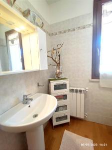 uma casa de banho com um lavatório branco e um espelho. em Tuscan Gallery House em Grosseto