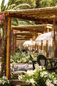 a wooden pergola with chairs and tables and flowers at Parco Ibiza, by Camping San Antonio est 1961 in San Antonio