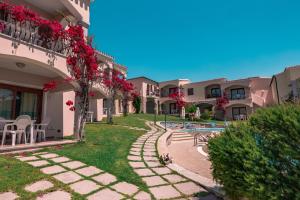 Fantastic Residenza Badus 1 BedRoomApart sleeps 4 plus possible child bed No0815 في باديسي: ساحة مبنى مع مسبح