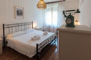 um quarto com uma cama com toalhas e um relógio em Montanari Home zona il S. Orsola em Bolonha