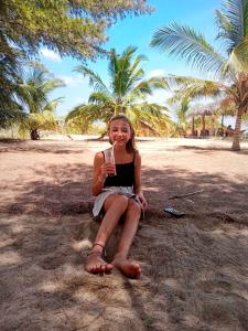 a young girl sitting on the beach with a drink at Ganesh Gate in Pottuvil