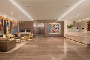 a lobby of a hotel with a painting on the wall at Citadines Salcedo Makati in Manila