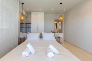 a bedroom with a large white bed with two white pillows at Marsane Luxury Appartments in Faliraki