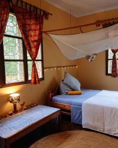 a bedroom with two beds and two windows at Kiwavi Home in Moshi