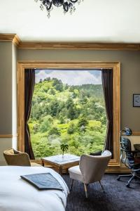 a room with a large window with a desk and chairs at Shelter Garden Nikko in Nikko +30 photos