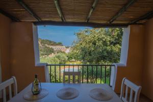 een tafel met uitzicht vanaf het balkon van een huis bij Beautiful Il Giardino degli Oleandri one bedroom sleeps two num0852 in Liscia di Vacca