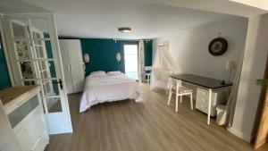 een slaapkamer met een bed, een bureau en een tafel bij 30mn de Paris st lazare en train, studio 42 m2 in Verneuil-sur-Seine