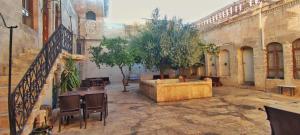 a courtyard with a table and trees in a building at Taşkıran Hotel in Urfa