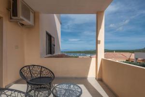 a balcony with a table and chairs and a view of the ocean at fantastico Baia de Bahas Residence one Bedroom four sleeps - child num0883 in Marinella