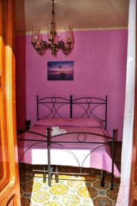 a pink bedroom with a bed with a pink wall at L' Arco Antico in Caccamo