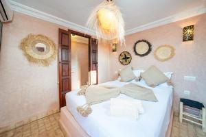a bedroom with a large white bed in a room at Riad Privé Dar L'Étoile - Jacuzzi Piscine & Petit Déj inclus in Marrakech +96 photos
