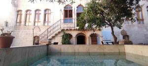 un patio de un edificio con una escalera y un árbol en Taşkıran Boutique Hotel en Sanlıurfa