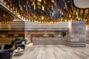 Un vestíbulo de un hotel con un mostrador de recepción y lámparas de araña. en Meriton Suites Pitt Street, Sydney, en Sídney