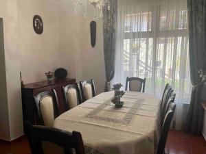 una sala da pranzo con tavolo, sedie e finestra di Vila Tequila Sinaia a Sinaia